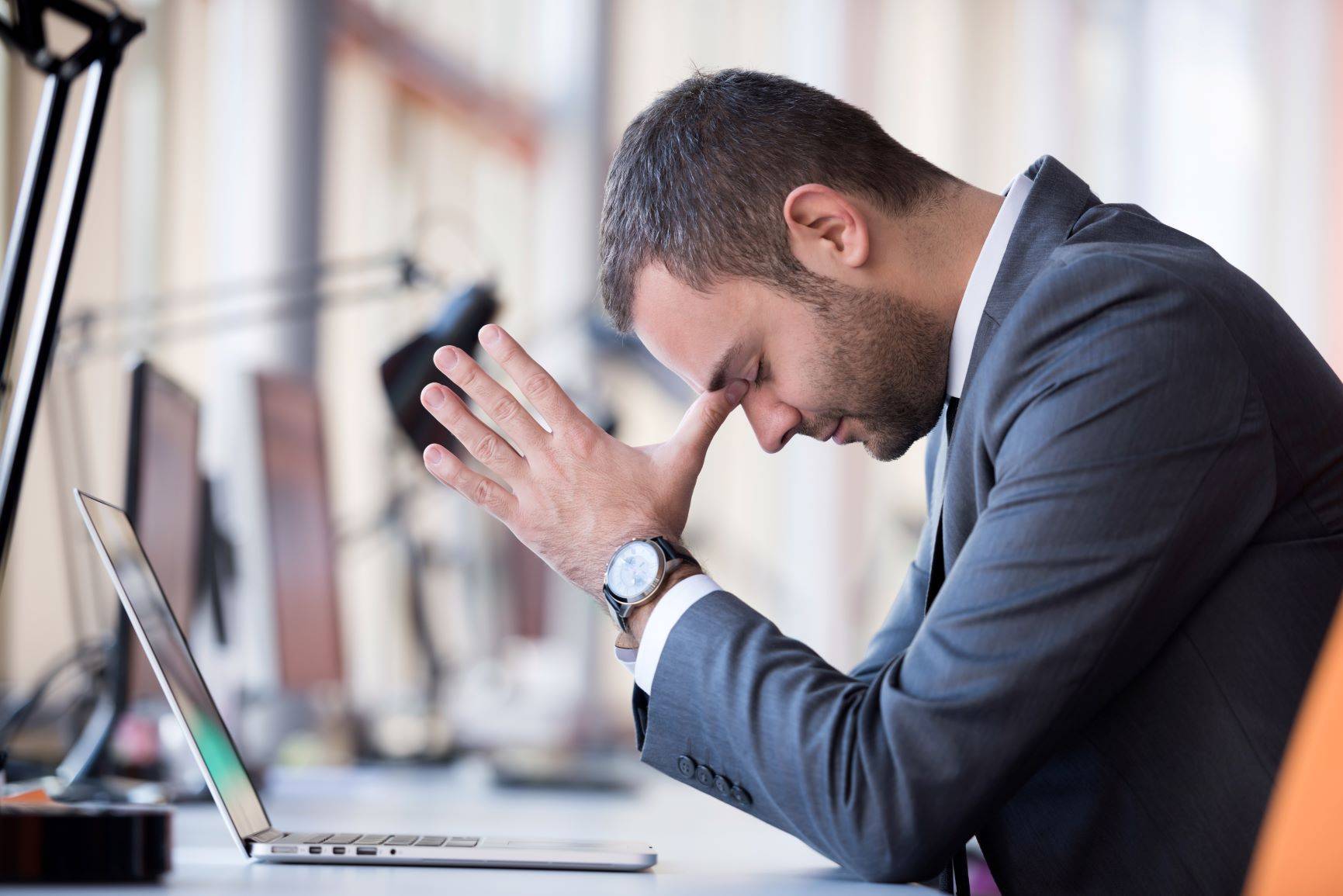 A man in a suit sat at a laptop computer